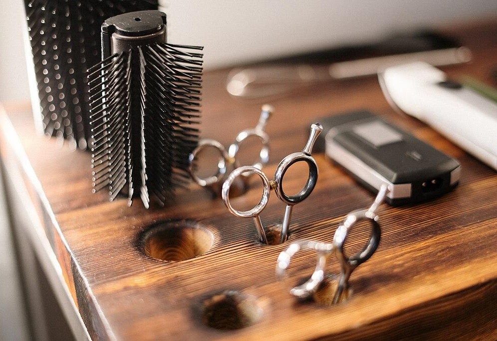 Salon tools — brushes, scissors and clippers on a wooden station